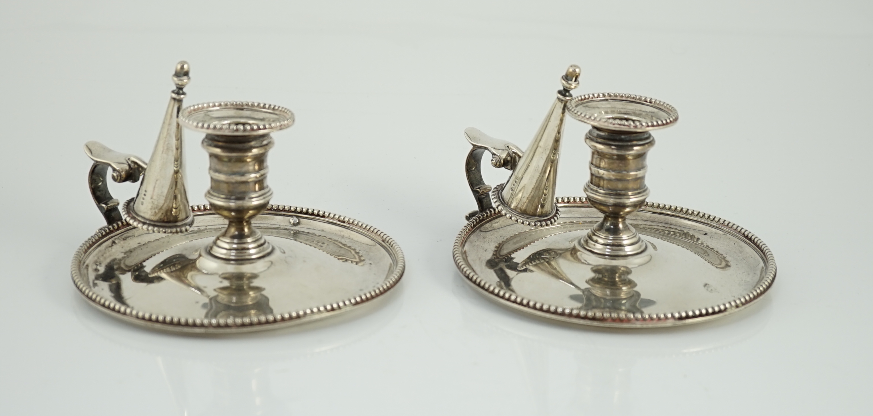 A pair of Victorian silver chambersticks and extinguishers, by Charles Thomas Fox and George Fox